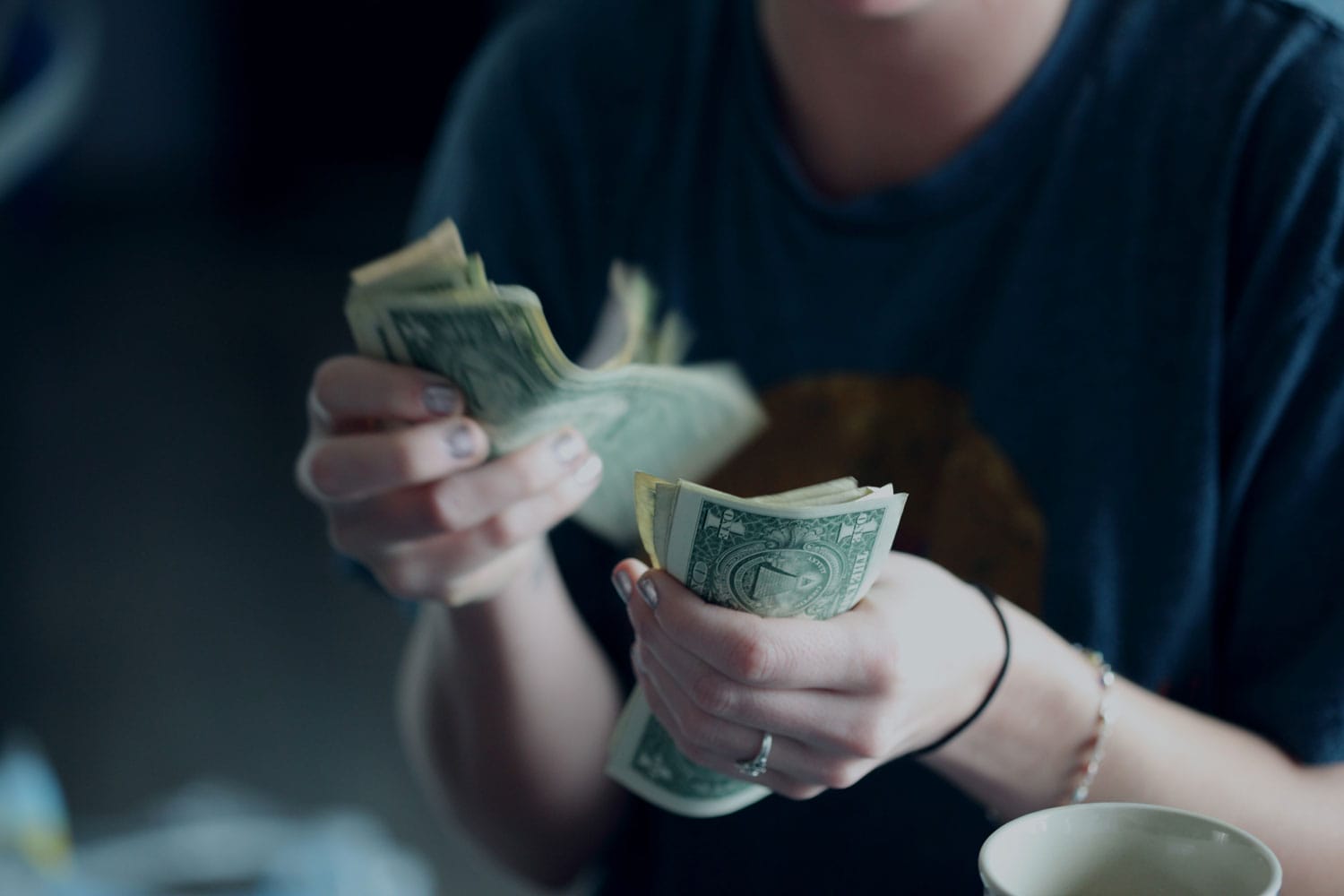 A woman counting American one dollar bills