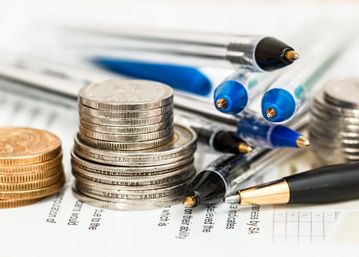 Stacks of U.S. coins and pens laying on a tax document