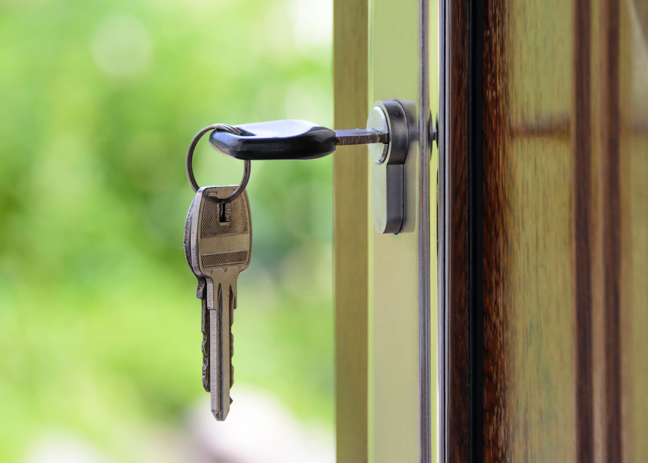 A set of keys hanging within a door lock